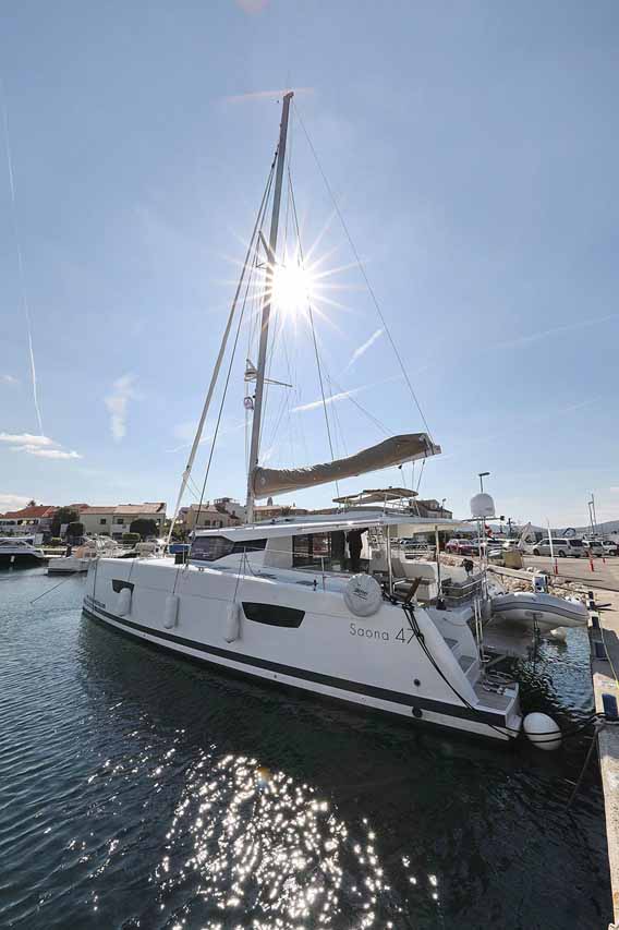 Sleek profile of the Fee yacht docked, showcasing its elegant hull and sunlit deck.