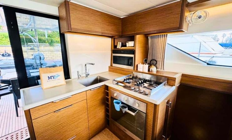 Sleek and modern THOR yacht kitchen featuring warm wood finishes and high-end appliances.