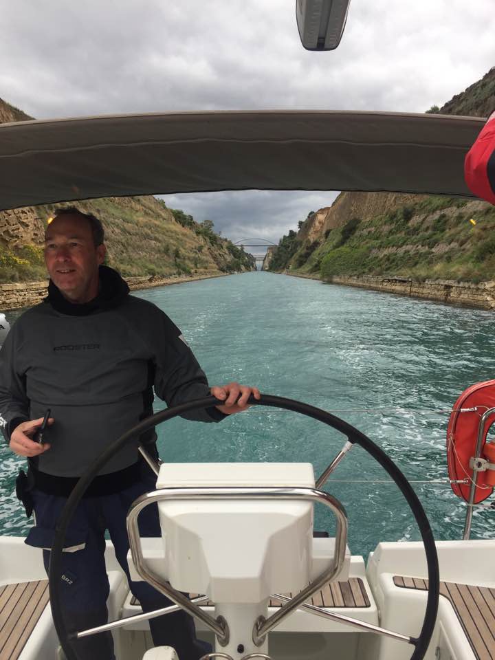 Captain navigating Arosa through a scenic canal, showcasing stunning natural landscapes.