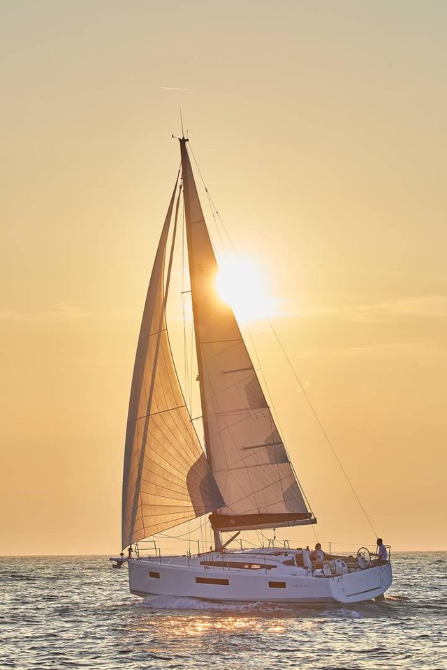 Sea Breeze gracefully sails against a stunning sunset, showcasing its elegant profile and billowing sails.