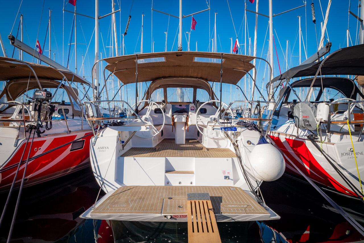 Amiya's elegant stern showcases a spacious cockpit and luxurious teak decking, surrounded by masts.