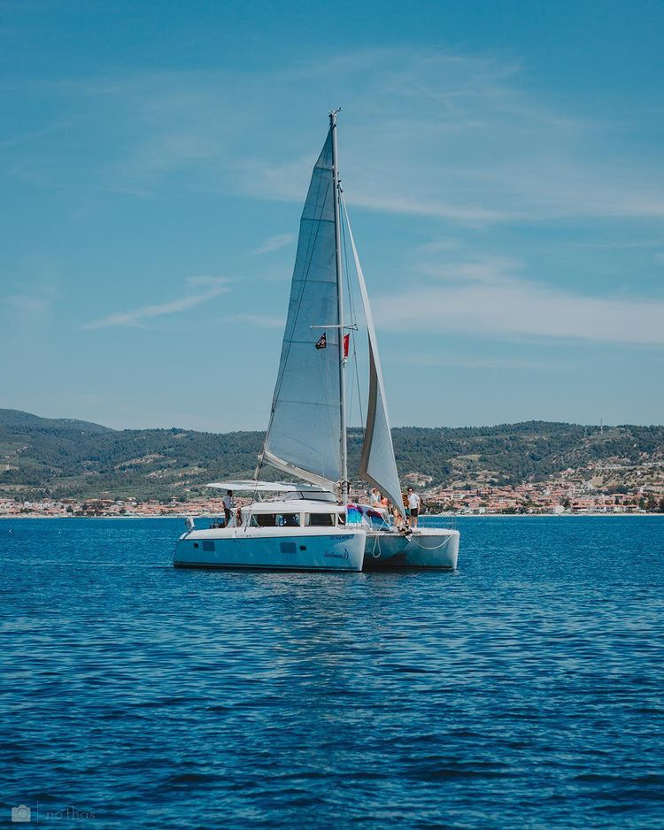 Dynamis gliding gracefully through azure waters, showcasing its elegant hull and sail design.