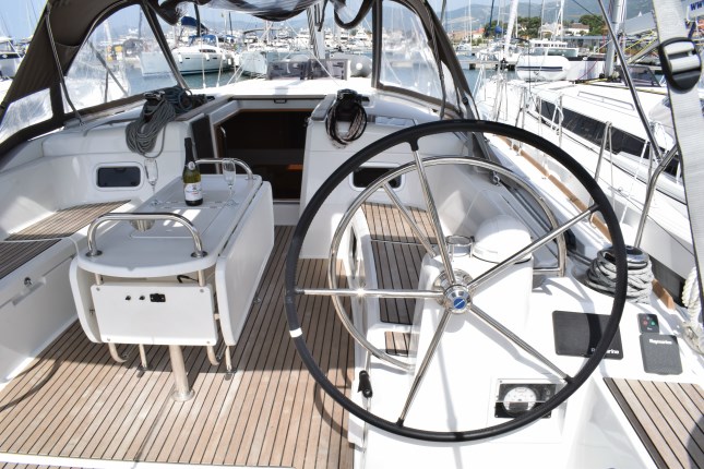 Sleek helm area of Purple Rain featuring modern controls and elegant teak flooring.