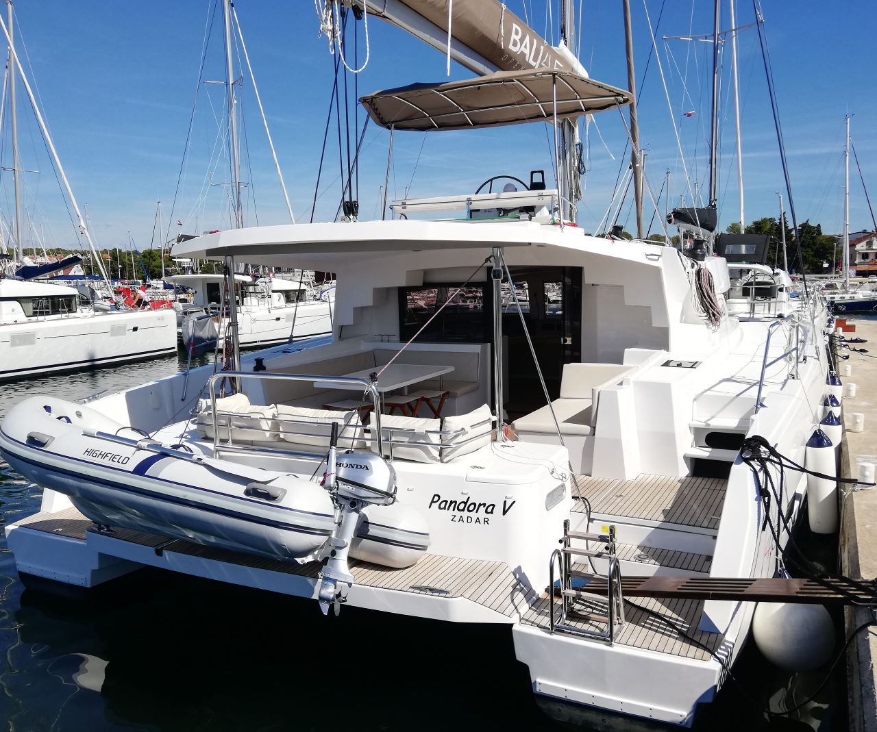 Elegant profile of Pandora V at the marina, showcasing sleek lines and inviting deck space.