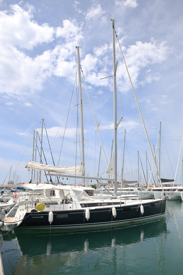 Elegant San Clemente yacht docked at a marina, showcasing its sleek hull and masts.