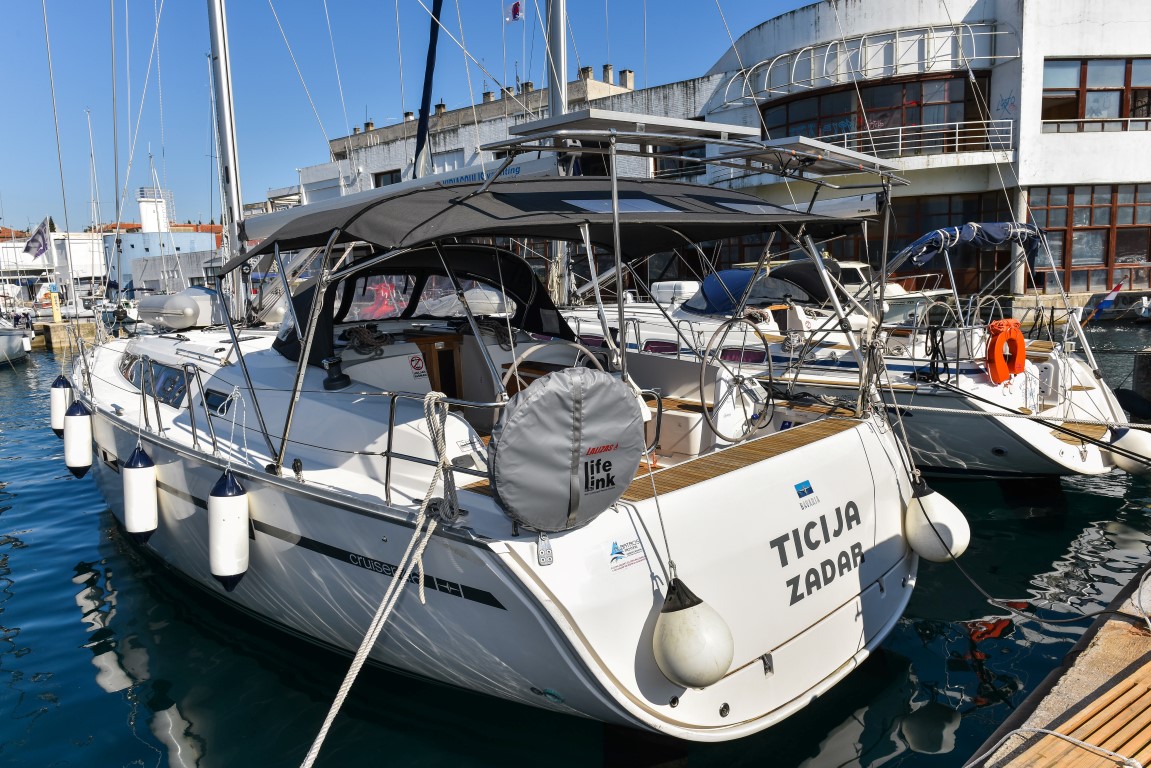 Elegant profile of Ticija docked, showcasing its sleek hull and inviting cockpit design.