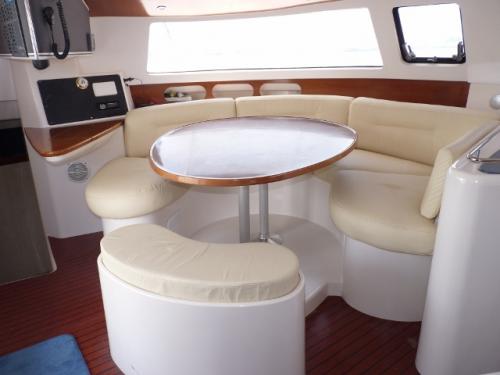 Elegant dining area aboard Artemis K., featuring plush seating and refined wood accents.